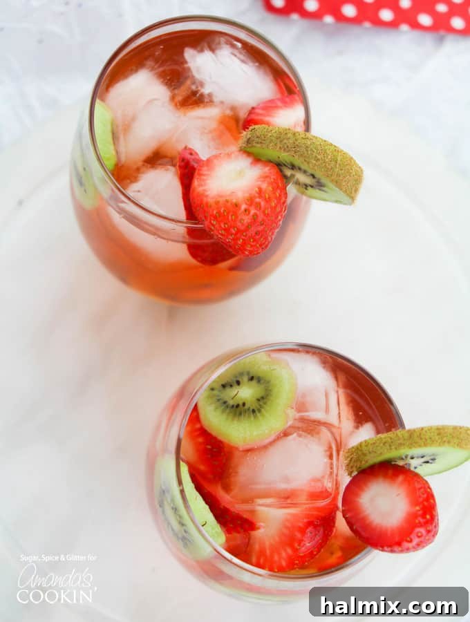 Overhead view of a glass pitcher filled with Strawberry Kiwi Sangria and fresh fruit.