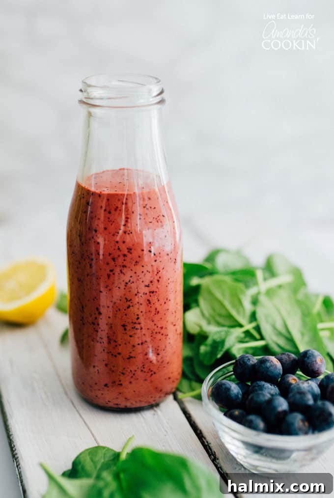 This homemade blueberry vinaigrette salad dressing is quick to make and bursting with fresh, tangy-sweet flavor. Perfect for summer salads, it's creamy, velvety, and naturally delicious. Blueberry Vinaigrette Dressing in a glass bottle with fresh blueberries