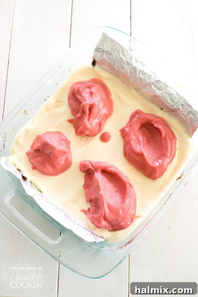 Spreading softened raspberry sherbet over a layer of vanilla ice cream for the frozen delight.