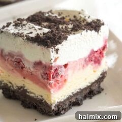 A slice of Frozen Raspberry Delight, showcasing the layered dessert.