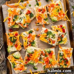 Slices of Appetizer Veggie Pizza on a parchment paper lined board