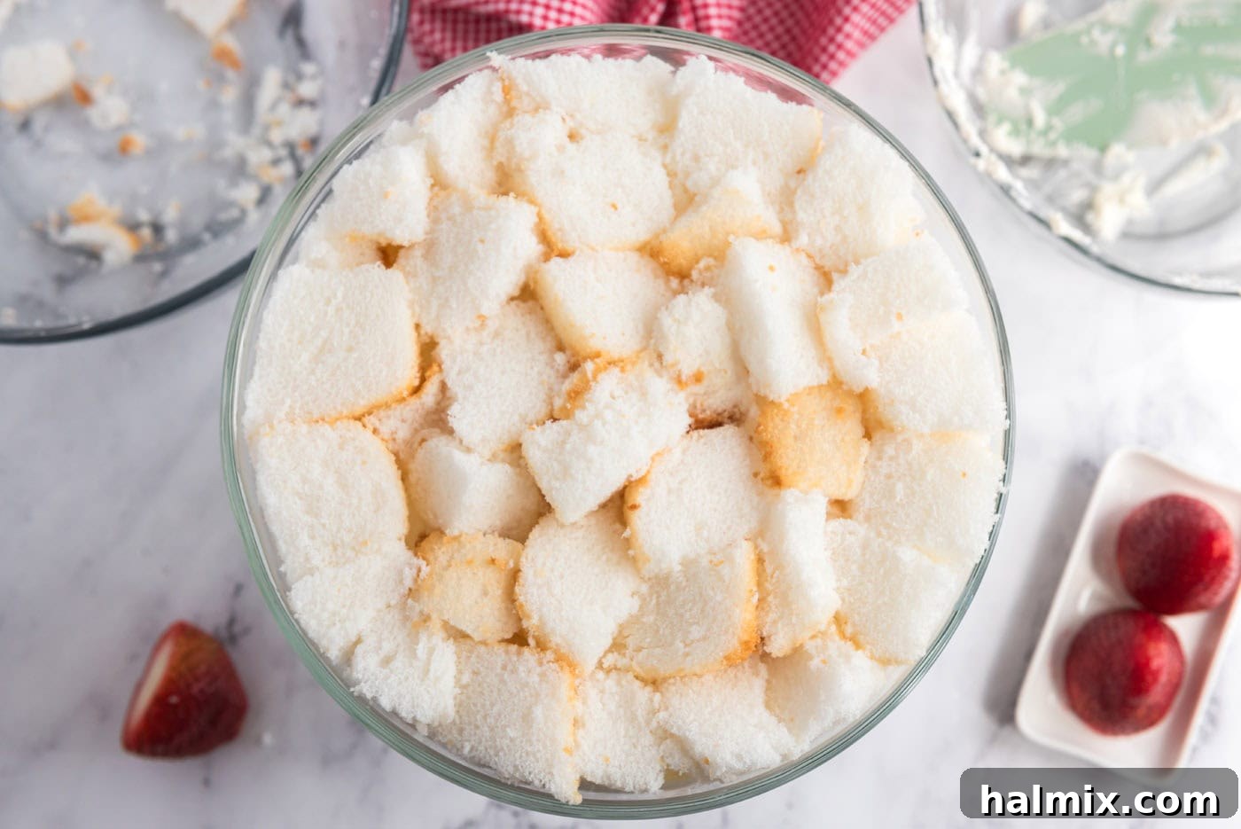 angel food cake cubes on top of strawberry shortcake trifle