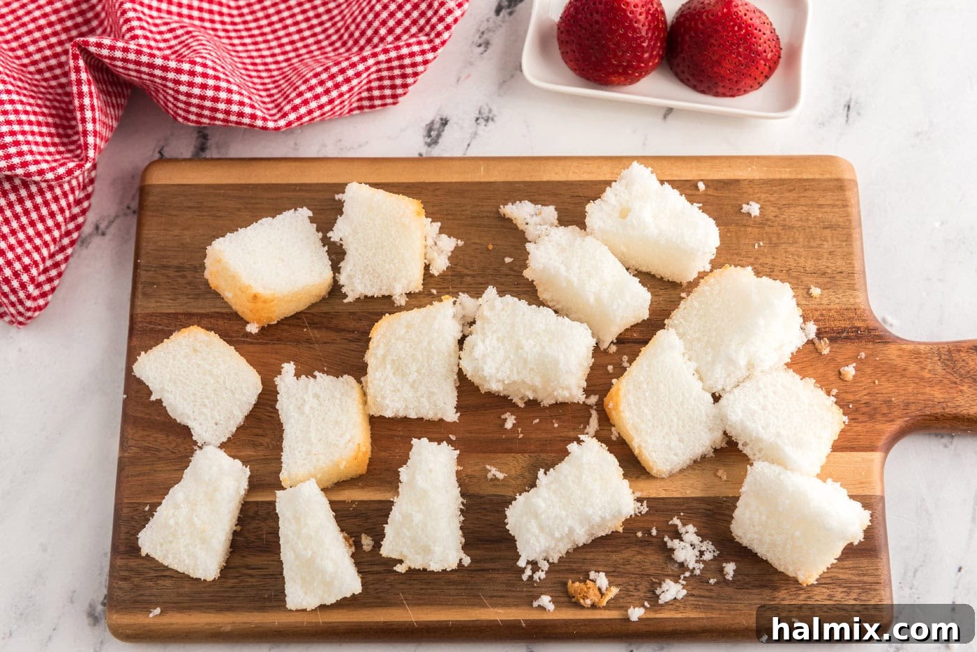 cubed angel food cake on a cutting board