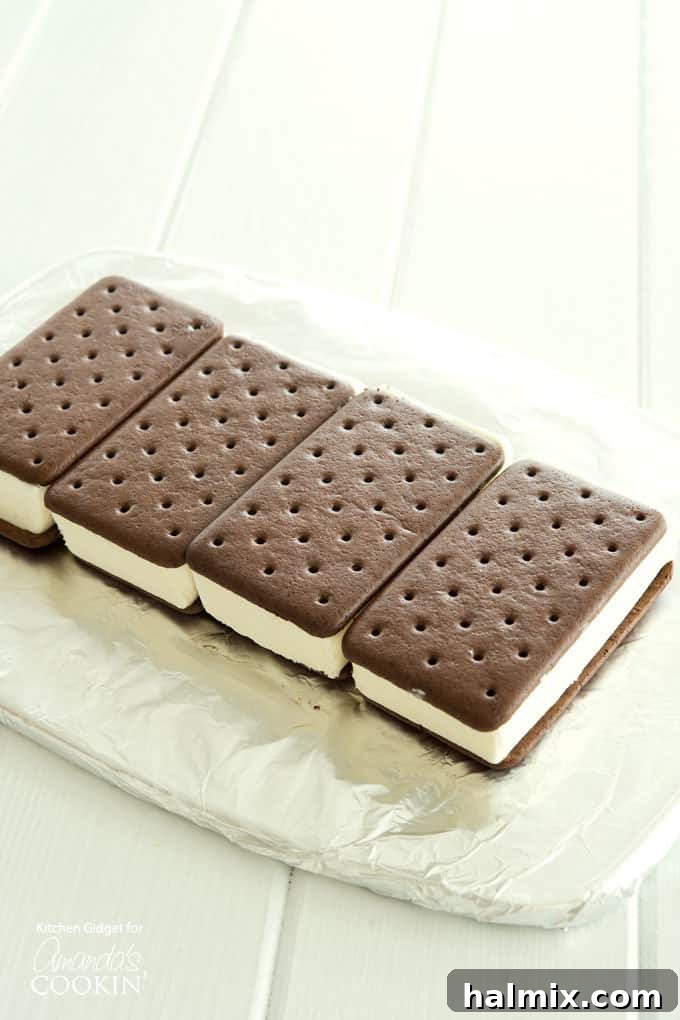 The first layer of ice cream sandwiches meticulously arranged side-by-side to form the base of the no-bake cake.