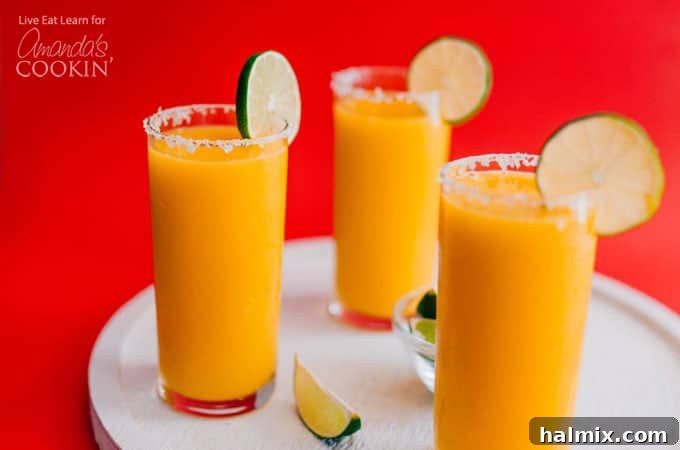 Mango Margarita Slush in glasses with a salted rim and lime garnish.
