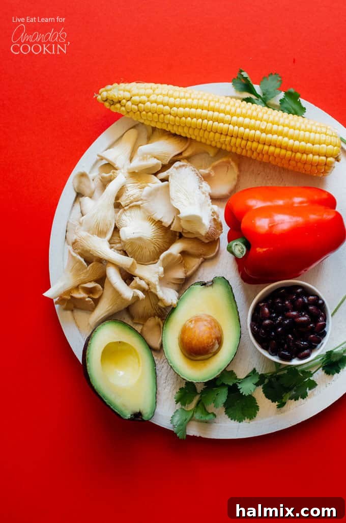Key ingredients for Mexican style summer rolls including fresh produce and spices. A vibrant selection of fresh ingredients laid out on a clean wooden table, ready for making Mexican style summer rolls. Ingredients include thinly sliced bell peppers, creamy avocado, crisp carrots, black beans, fresh corn, and a pile of oyster mushrooms and cilantro.