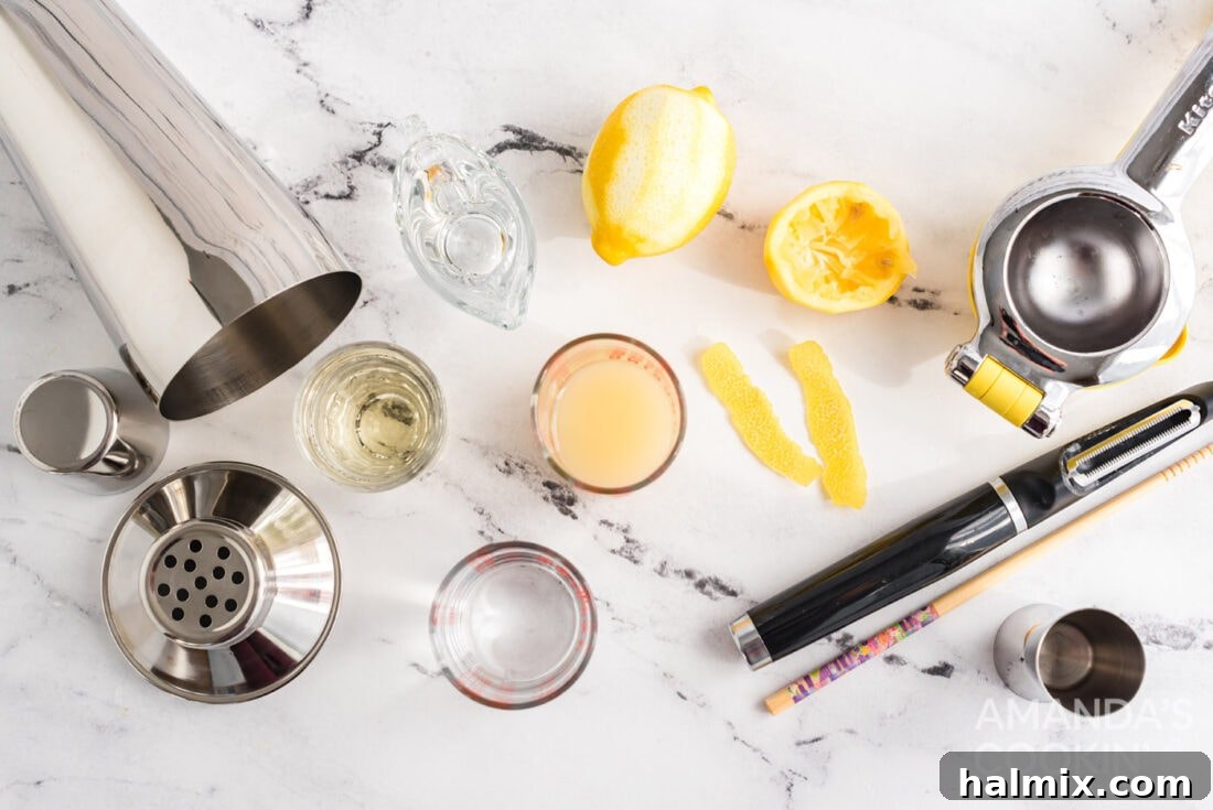 A flat lay showing all the fresh ingredients and liquor needed to make a Lemon Drop cocktail, including lemons, vodka, triple sec, and simple syrup.