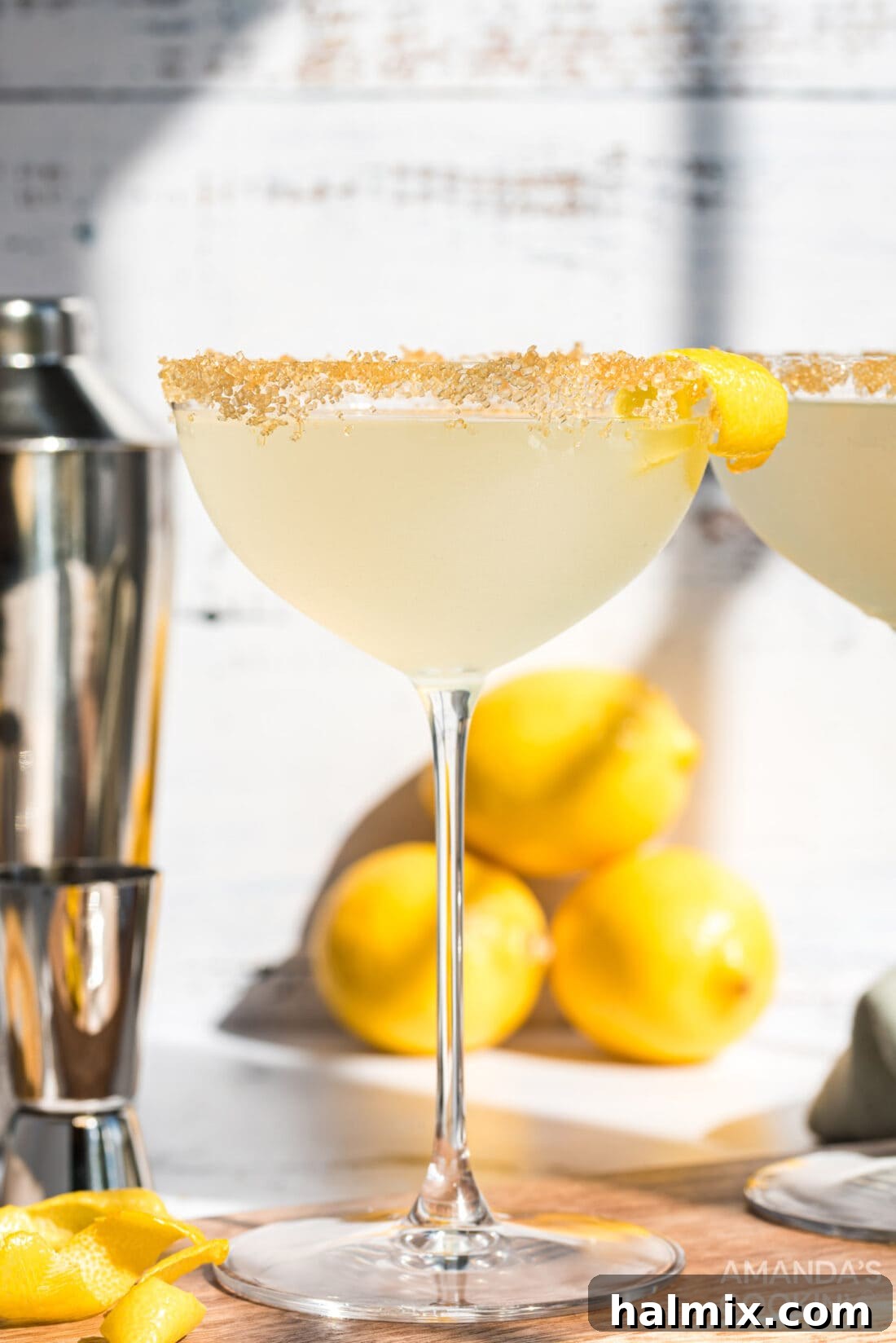 A close-up of a perfectly garnished Lemon Drop cocktail in a martini glass with a sugared rim.