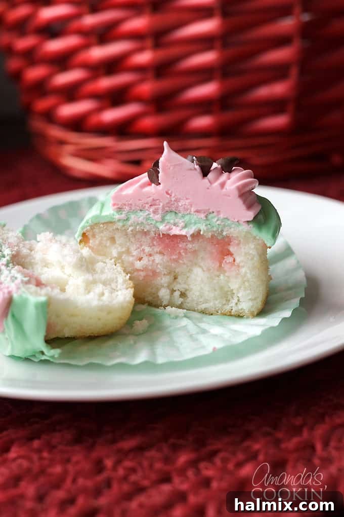 Cross-section of Watermelon Poke Cupcake A watermelon poke cupcake cut in half, revealing the pink Jell-O infused center