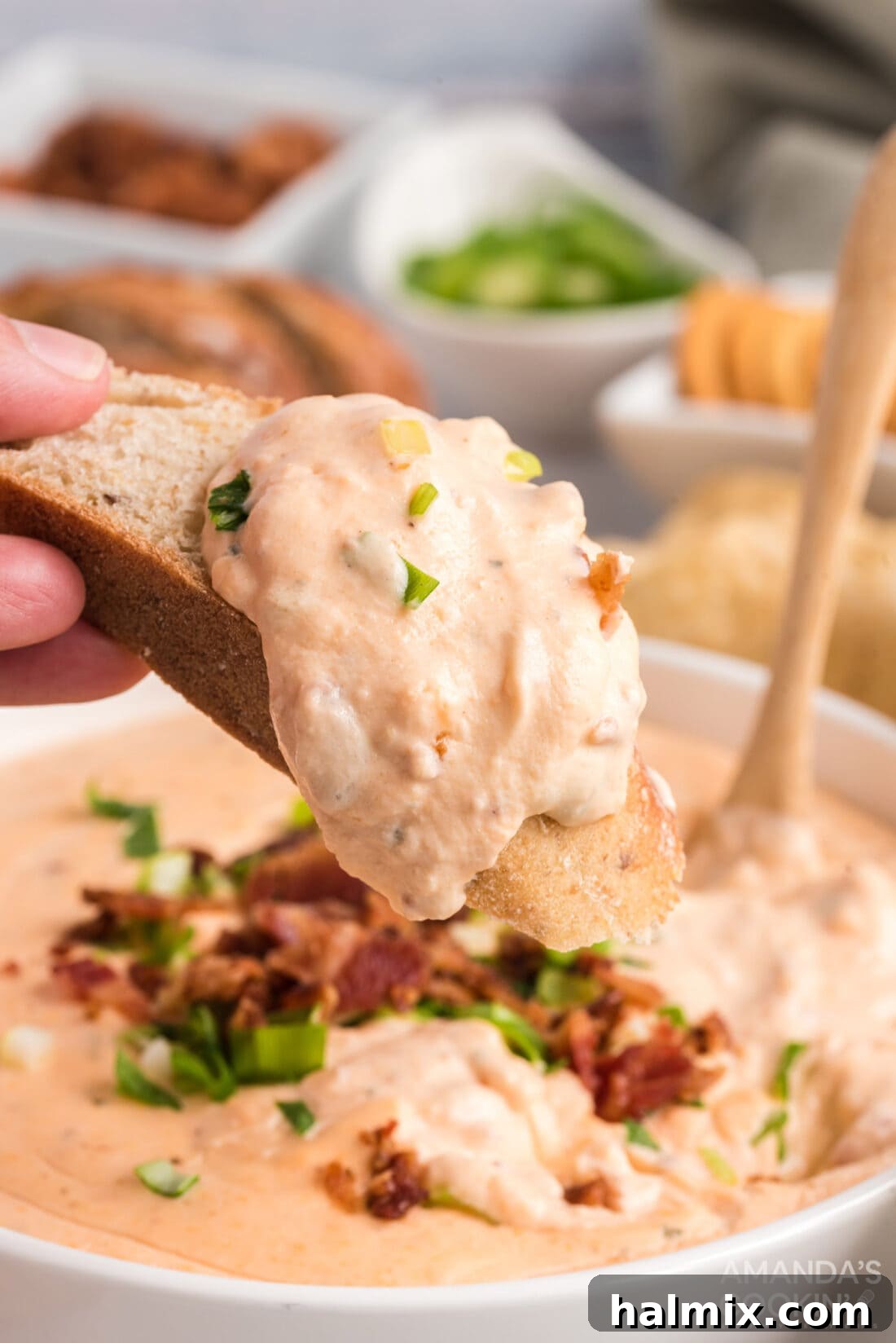 Warm, golden Crockpot Cheese Dip in a serving bowl, surrounded by various dippers like bread slices and crackers, ready for a party.