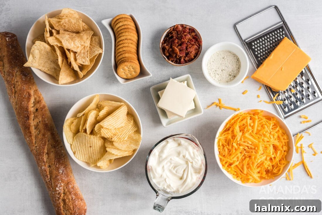 A flat lay of all the ingredients needed for Crockpot Cheese Dip, including cream cheese, sour cream, cheddar, bacon, and ranch seasoning.