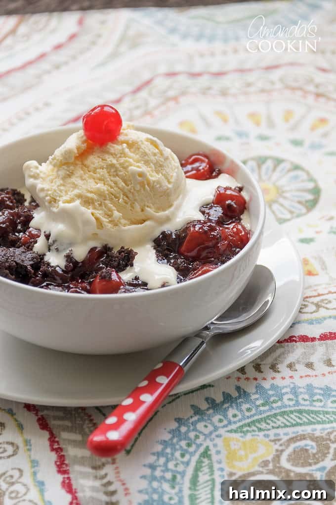 Delicious crockpot chocolate cherry cobbler with a scoop of melting vanilla ice cream, perfect for a quick Black Forest-inspired dessert.