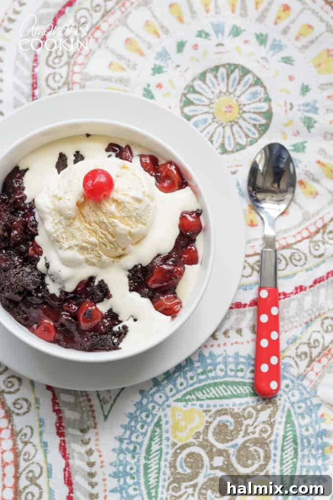 Close-up of a warm, bubbling cherry cobbler fresh from the crockpot, ready to be served.