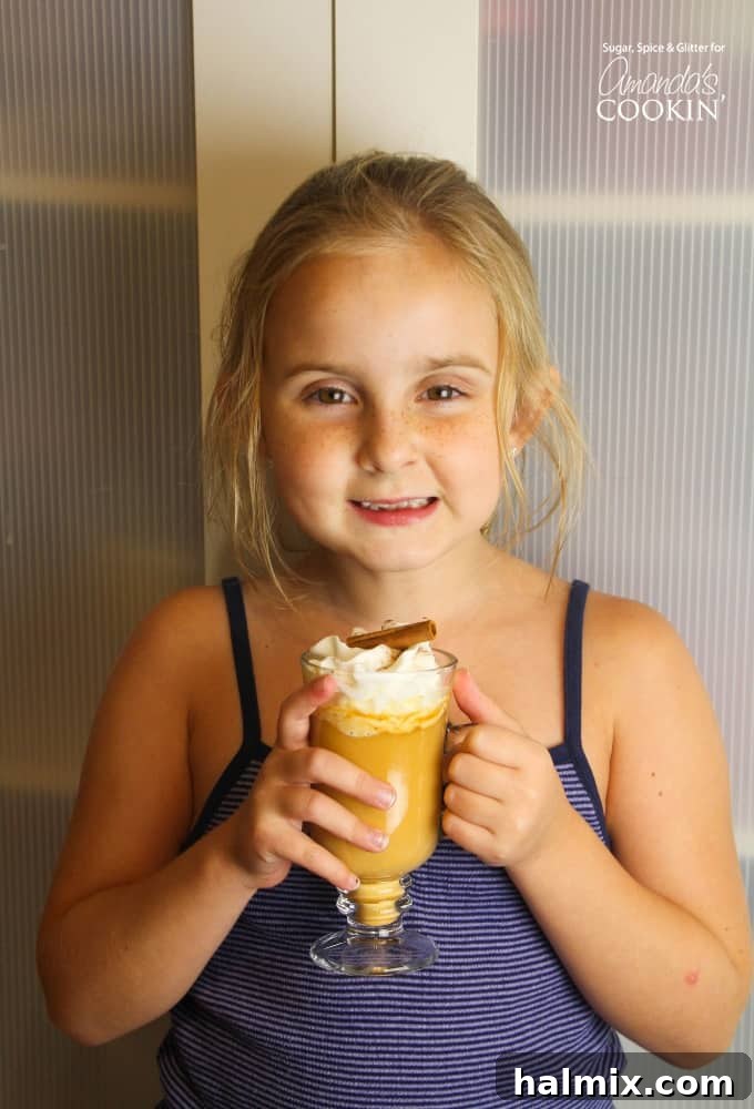 Girl holding pumpkin spice hot chocolate in a mug