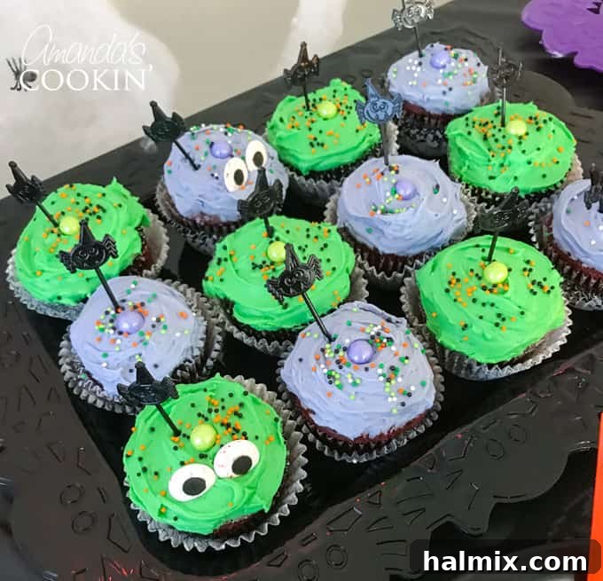 If you need Halloween food ideas for your Halloween party, be sure to check out all these sweet, savory and beverage ideas! Something for everyone. #halloweenrecipes #halloweenfoodideas #halloweenfood #halloweentreats #halloweenpartyfood #mummycookies #mozarellaeyeballs #spidertacodip #spidercookies #ricekrispypumpkins #ricekrispymonsters #dipinapumpkin #halloweenparty Halloween-themed chocolate cupcakes with purple and green frosting and candy eyes