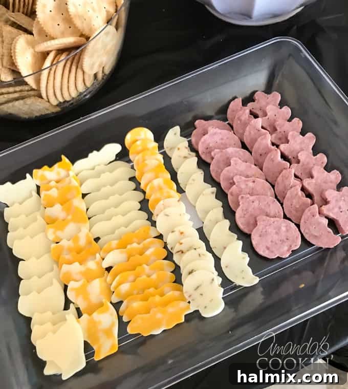 If you need Halloween food ideas for your Halloween party, be sure to check out all these sweet, savory and beverage ideas! Something for everyone. #halloweenrecipes #halloweenfoodideas #halloweenfood #halloweentreats #halloweenpartyfood #mummycookies #mozarellaeyeballs #spidertacodip #spidercookies #ricekrispypumpkins #ricekrispymonsters #dipinapumpkin #halloweenparty Halloween-themed cookie cutter cheese and sausage platter