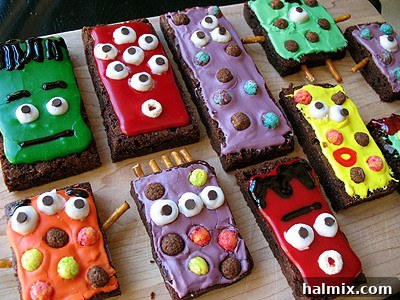 If you need Halloween food ideas for your Halloween party, be sure to check out all these sweet, savory and beverage ideas! Something for everyone. #halloweenrecipes #halloweenfoodideas #halloweenfood #halloweentreats #halloweenpartyfood #mummycookies #mozarellaeyeballs #spidertacodip #spidercookies #ricekrispypumpkins #ricekrispymonsters #dipinapumpkin #halloweenparty Colorful monster brownie treats with candy eyes and sprinkles
