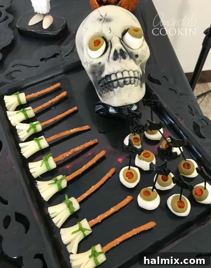 If you need Halloween food ideas for your Halloween party, be sure to check out all these sweet, savory and beverage ideas! Something for everyone. #halloweenrecipes #halloweenfoodideas #halloweenfood #halloweentreats #halloweenpartyfood #mummycookies #mozarellaeyeballs #spidertacodip #spidercookies #ricekrispypumpkins #ricekrispymonsters #dipinapumpkin #halloweenparty Halloween pretzel broomsticks and mozzarella eyeballs on a platter