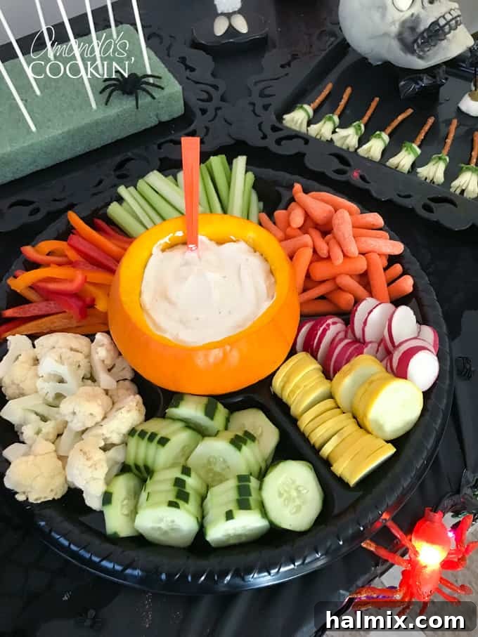 If you need Halloween food ideas for your Halloween party, be sure to check out all these sweet, savory and beverage ideas! Something for everyone. #halloweenrecipes #halloweenfoodideas #halloweenfood #halloweentreats #halloweenpartyfood #mummycookies #mozarellaeyeballs #spidertacodip #spidercookies #ricekrispypumpkins #ricekrispymonsters #dipinapumpkin #halloweenparty Fresh vegetables arranged around a pumpkin filled with dip
