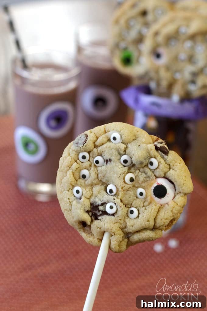 Turn your favorite chocolate chip cookie recipe into fun Monster Eyeball Cookie Pops for Halloween. A treat kids and adults will love! #halloweencookies #monstercookies #eyeballcookies #chocolatechipcookies #halloweenrecipes #candyeyeballs #lollipops #cookiepop Monster Eyeball Cookie Pops for Halloween