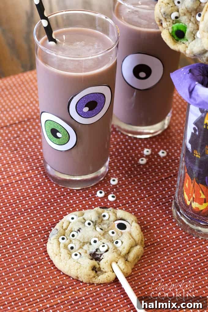 Monster Eyeball Cookie Pops and chocolate milk for Halloween. A fun treat for kids and adults! #halloweencookies #monstercookies #eyeballcookies #chocolatechipcookies #halloweenrecipes #candyeyeballs #lollipops #cookiepop Monster Eyeball Cookie Pops with Monster Chocolate Milk