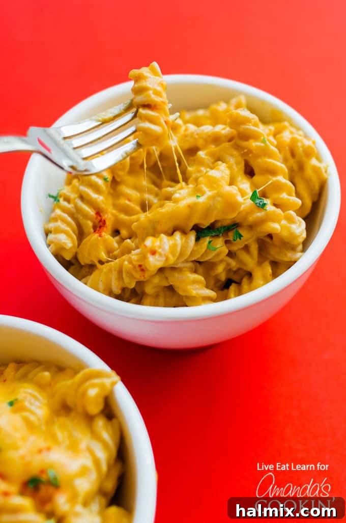 Butternut Squash Macaroni and Cheese served in a bowl, garnished with fresh herbs.