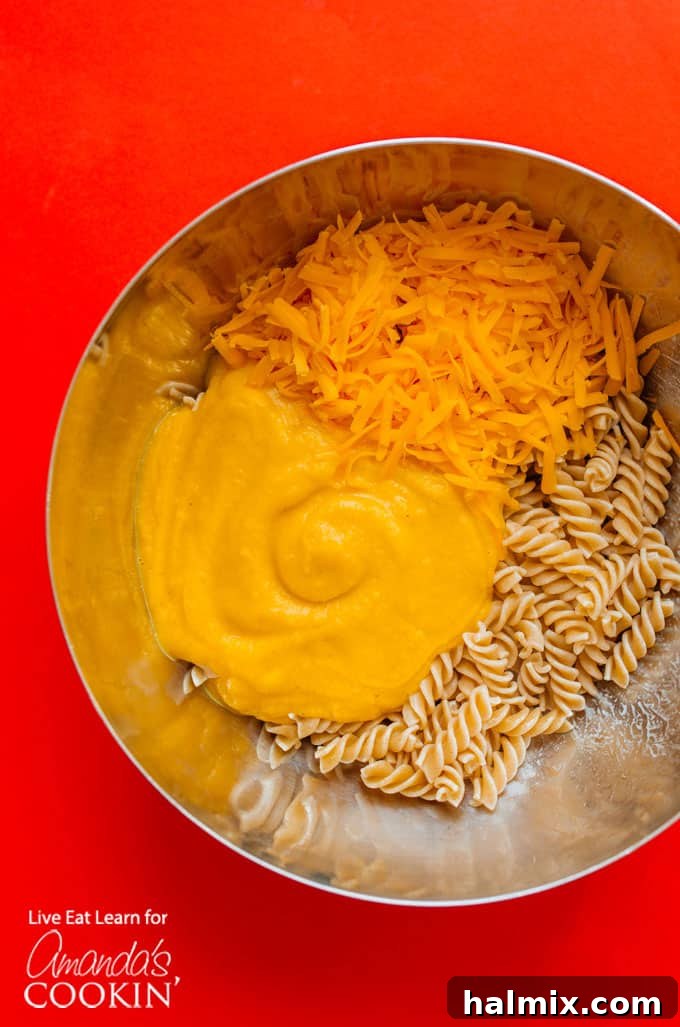 A spread of fresh ingredients for Butternut Squash Mac and Cheese, including squash, pasta, cheese, and yogurt.