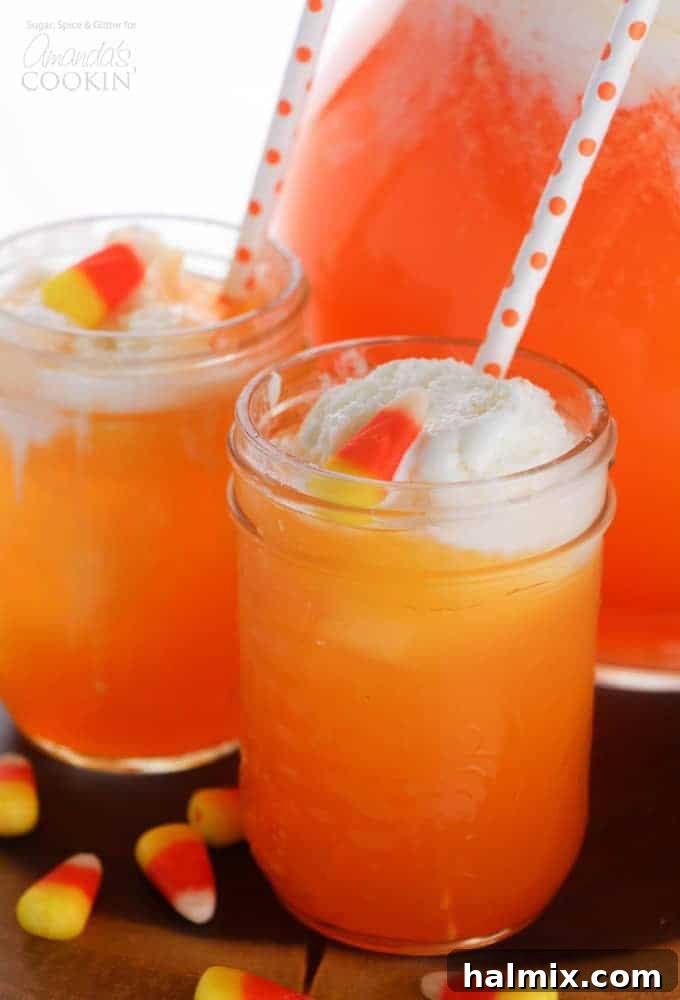 Candy corn punch for Thanksgiving or fall! Candy corn punch in a glass with straws