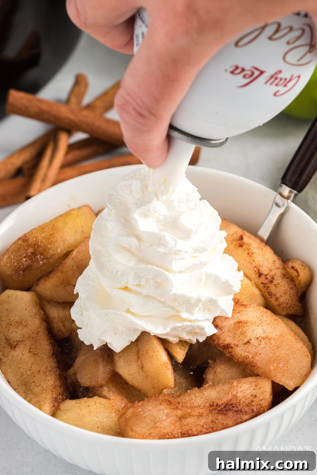Slow-Cooked Apple Cinnamon Delight 8 adding whipped cream to Crockpot Cinnamon Apples