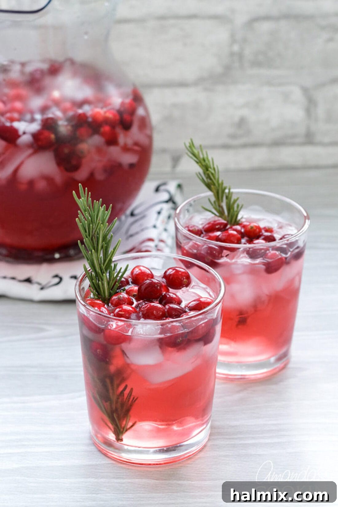 Make this Cranberry Holiday Punch for your Thanksgiving dinner or Christmas party! cranberry holiday punch garnished with fresh rosemary sprigs and cranberries