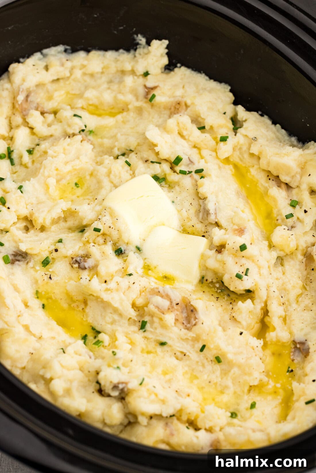 Easy Creamy Slow Cooker Mashed Potatoes 2 Creamy mashed potatoes and gravy on a white plate, ready to be served.