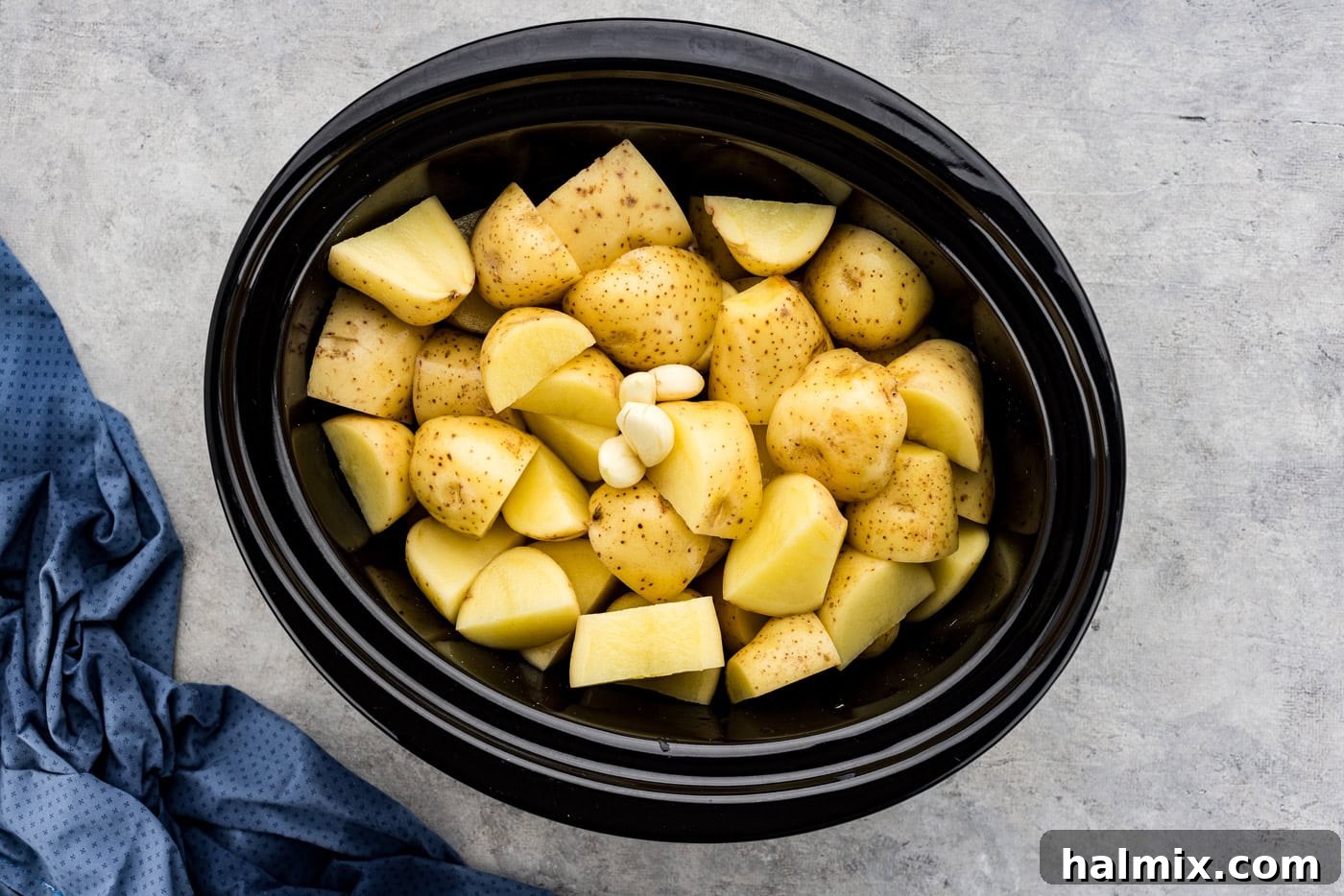 Easy Creamy Slow Cooker Mashed Potatoes 6 Whole garlic cloves added to the crockpot with Yukon Gold potatoes and chicken broth.