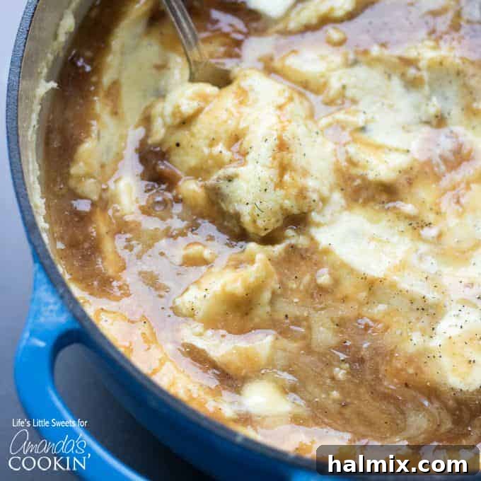 Creamy Traditional Mashed Potatoes with Gravy Rich and creamy mashed potatoes served in a blue bowl, topped with gravy.