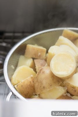 Hot, drained potatoes steaming in a colander.