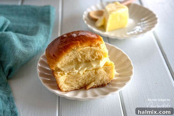 Soft homemade Hawaiian rolls on a plate with butter, ready to serve