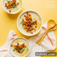 three bowls of cauliflower soup with chickpea garnish