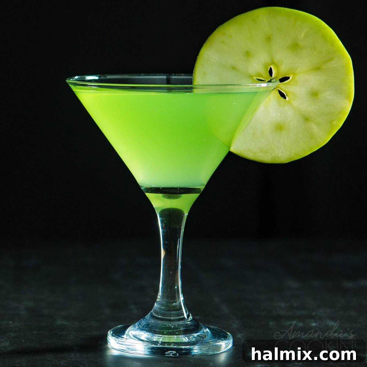 A Perfectly Balanced Sweet and Tart Apple Cocktail A solitary Appletini in a martini glass on a dark background, perfectly lit, showcasing its allure and readiness to be enjoyed.