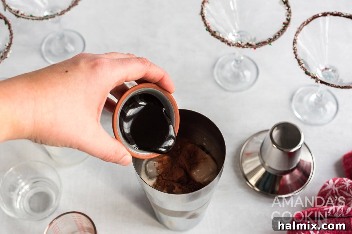 Ingredients being poured into a cocktail shaker for a chocolate peppermint martini.