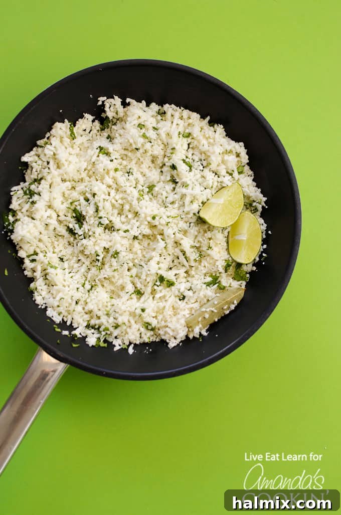 Close-up of Copycat Cauliflower Chipotle Rice cooking in a skillet with fresh cilantro