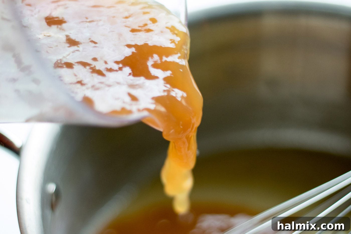 Pan drippings being added into a saucepan
