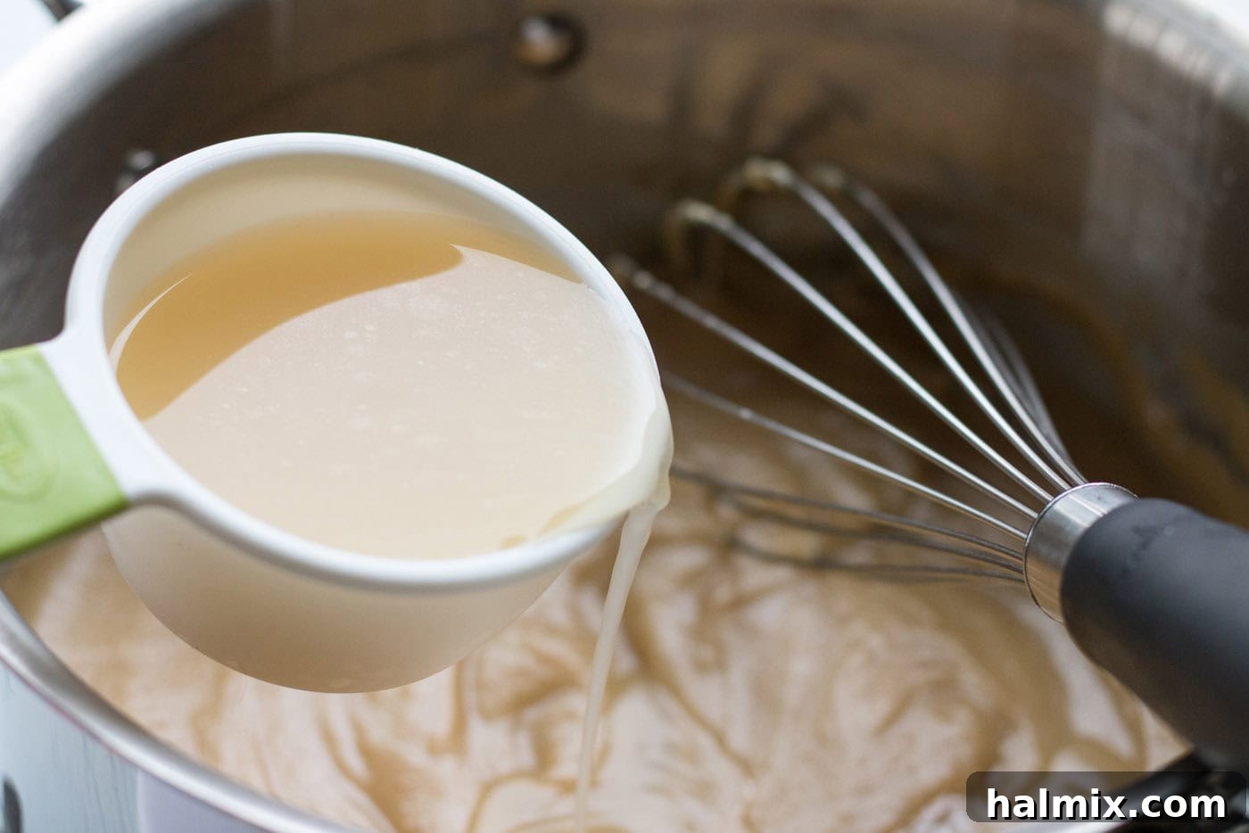 Broth being added into a saucepan
