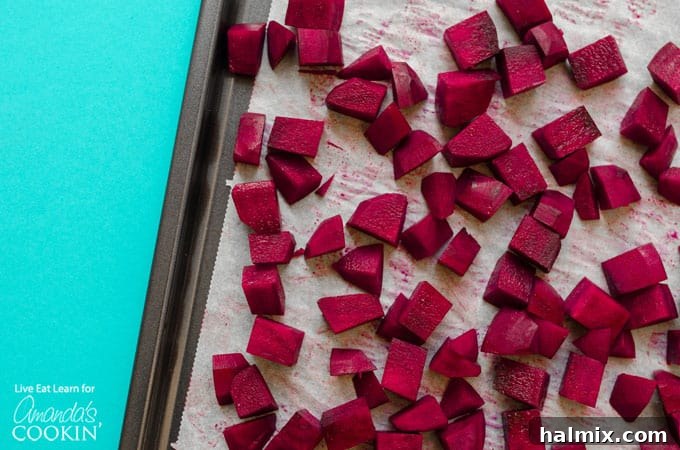 Fresh red beets, washed and ready for roasting, lying on a baking sheet, promising earthy sweetness for the salad.