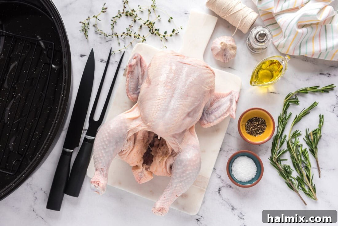 Golden Roasted Chicken 4 A collection of fresh ingredients laid out for roasting a chicken, including a whole raw chicken, olive oil, salt, pepper, and fresh herbs like rosemary and thyme, all ready for preparation.