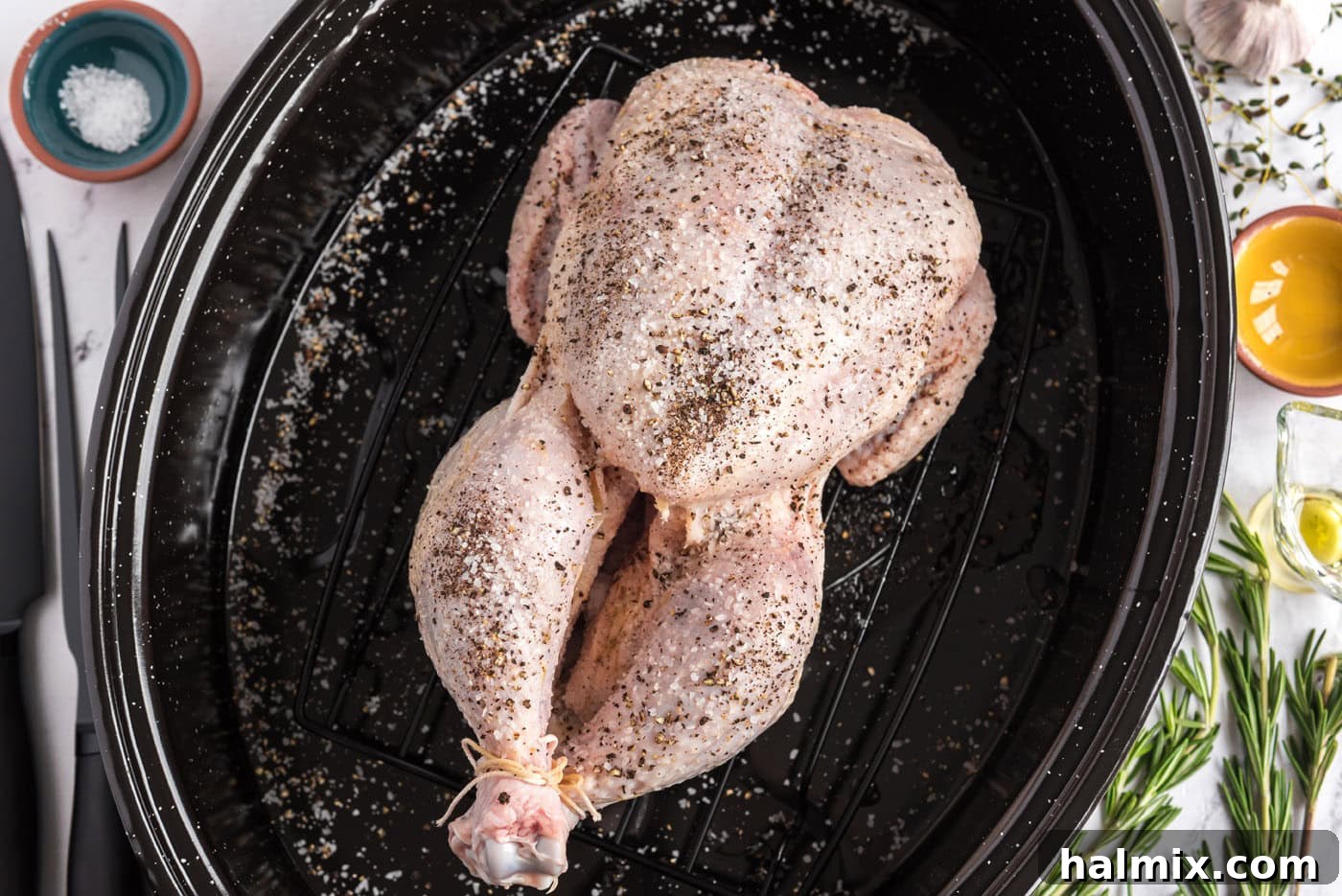 Golden Roasted Chicken 8 A whole raw chicken, rubbed with olive oil and seasoned generously with salt and pepper, ready for the oven.