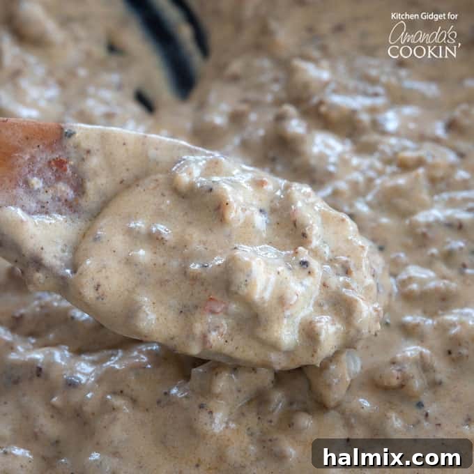 Close-up of golden-brown sausage crumbles in a cast iron skillet, ready to be transformed into a rich gravy.