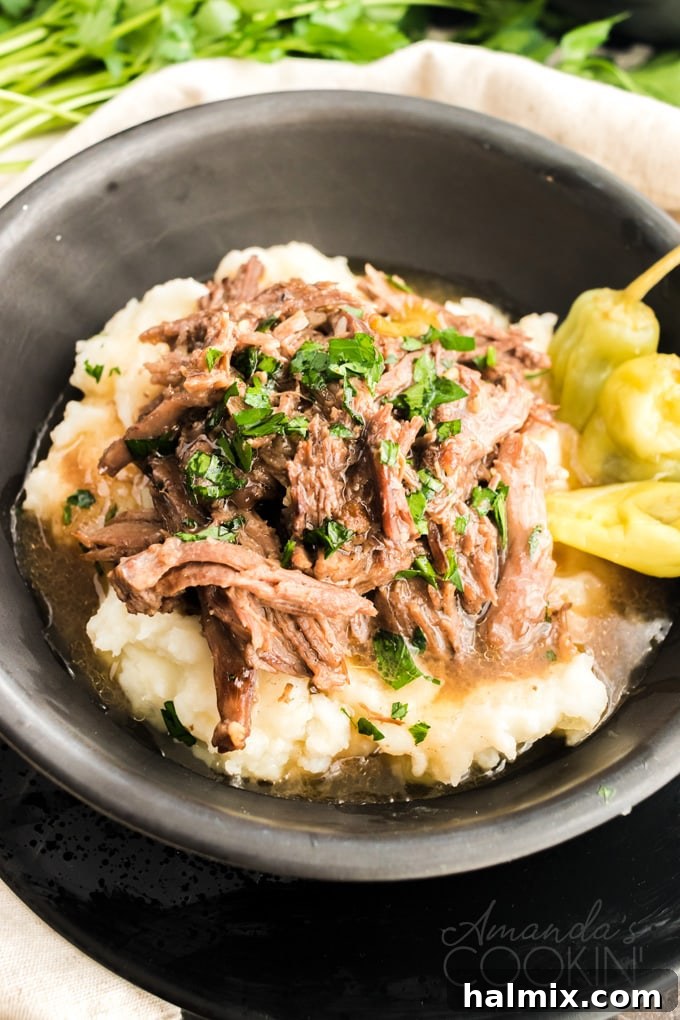 Delicious bowl of Mississippi Pot Roast with tender beef and savory gravy, served over creamy mashed potatoes, ready to be enjoyed.