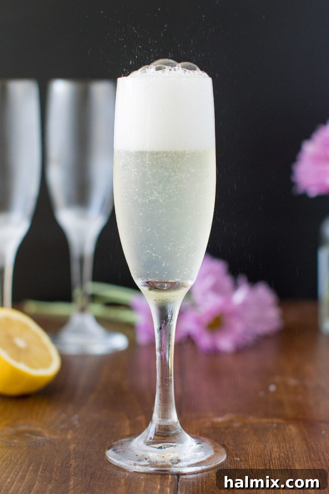 The delicate fizz of champagne bubbles rising in a tall, elegant flute, symbolizing the effervescence of a French 75 cocktail.
