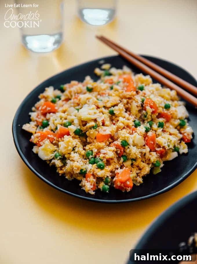 A vibrant bowl of Cauliflower Fried Rice, garnished and ready to be enjoyed. Perfect for a low carb and keto-friendly meal.