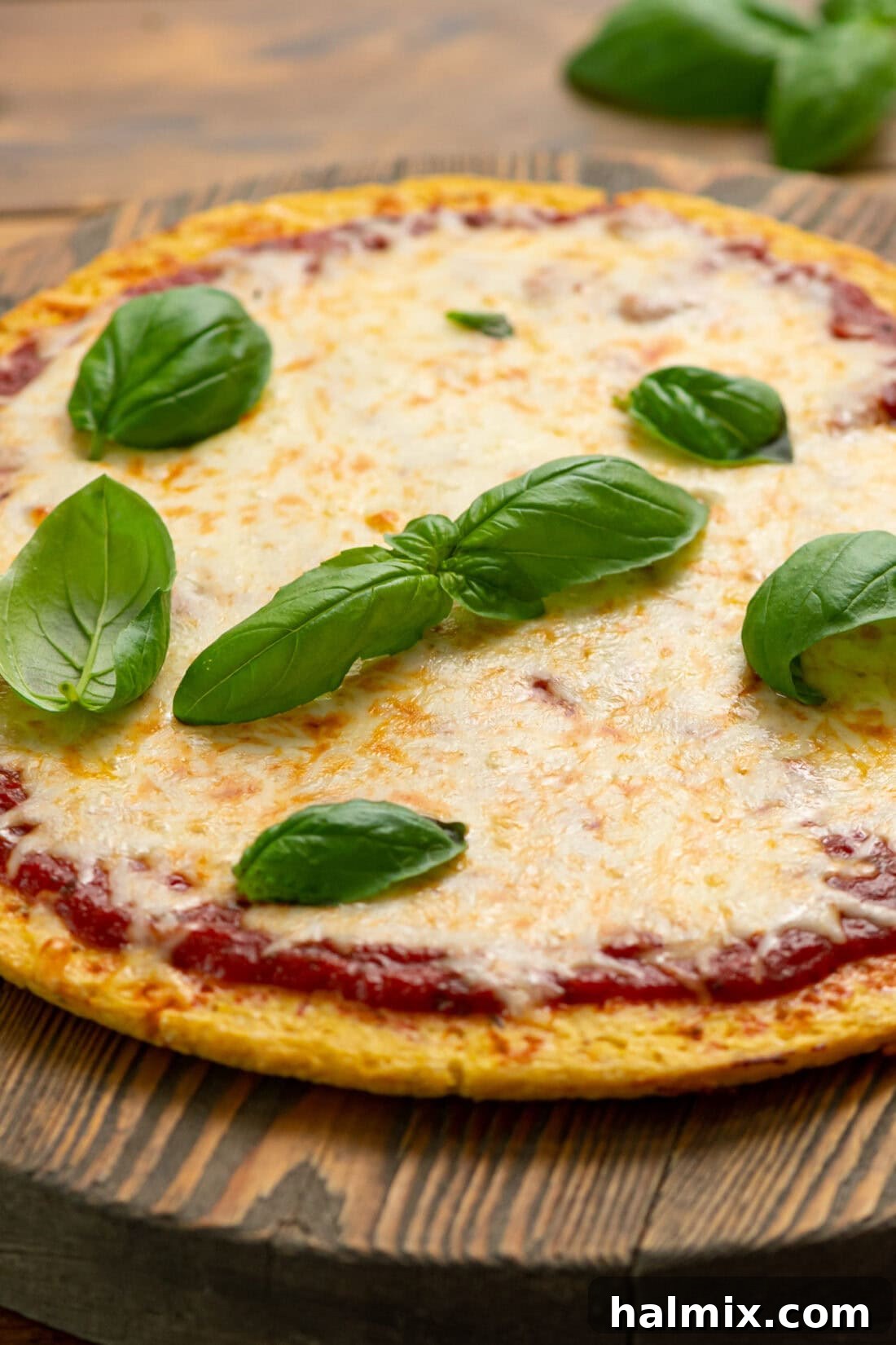 Cauliflower Pizza Perfection 7 Cauliflower Pizza Crust topped with fresh basil leaves, ready to be served.