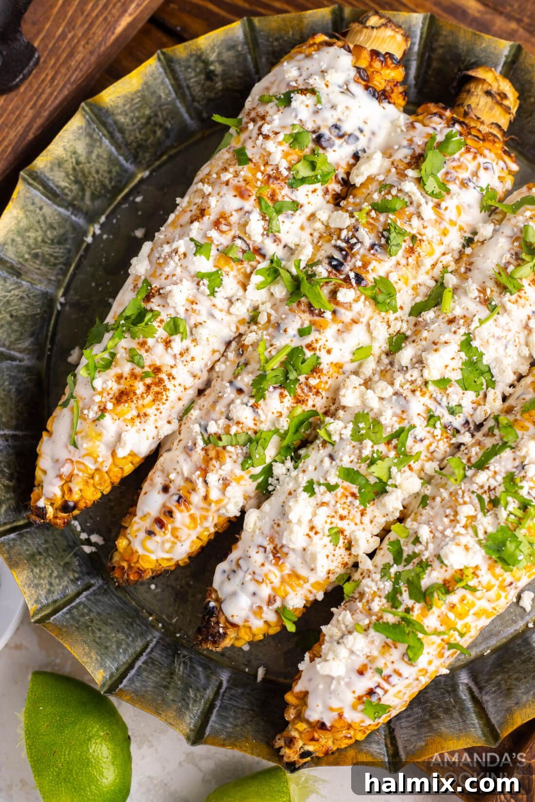 Mexican Street Corn Fiesta 2 A plate of freshly prepared Mexican street corn on the cob, garnished with cheese and spices.